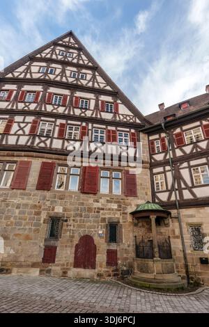 Historisches Fachwerkgebäude mit Steinbrunnen in Tübingen Stockfoto