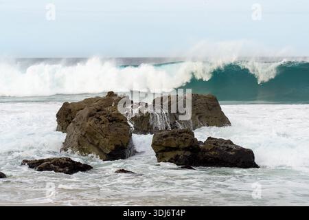 Eine große Welle bricht in der Nähe Eines Felsvorsprungs in der Nähe des Pacific Coast Highway in Kalifornien Stockfoto