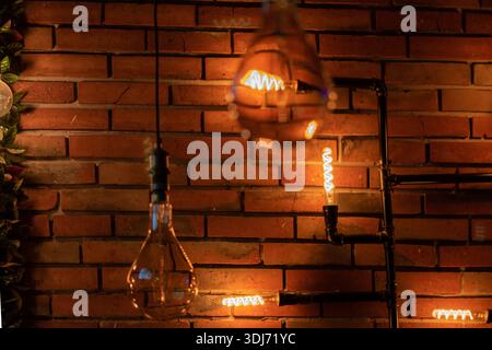 Glühbirnen beleuchten das Café mit Ziegelwänden. Stockfoto