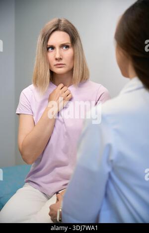 Arzt und Patientin diskutieren schlechte Diagnose, sitzen im Büro Stockfoto