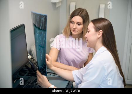 Arzt Neurologe zeigt Röntgenaufnahme bei Patienten in der Klinik Stockfoto