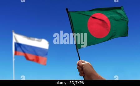 Bangladesch-Flagge winkt unter Wolken. Fliegen Sie in den Himmel. Foto der russischen Flagge mit absichtlich verschwommenem Hintergrund Stockfoto