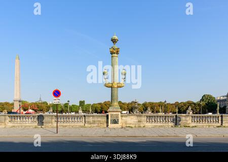 Paris, Frankreich - 18. Juli 2022: Eine dekorative historische Straßenlaterne steht im Vordergrund des Place de la Concorde mit dem Obelisken von Luxor auf der linken Seite, einem Schild ohne Parken und Bäumen unter einem klaren blauen Himmel. Stockfoto