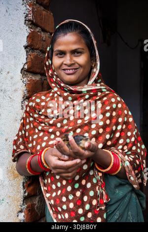 Porträt einer jungen Frau aus dem ländlichen Odisha, die eine kleine Küken in Indien hält Stockfoto