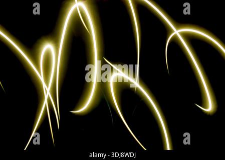 Elegante goldene helle Linien, die abstrakte Bewegungen auf dunklem Hintergrund bilden. Moderner Energiefluss und luxuriöses digitales Kunstkonzept. Stockfoto