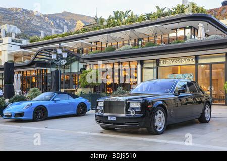 Porsche 911 Carrera S und Rolls Royce Phantom vor der Boutique Tiffany & Co. Neben Cafe de Paris, Place du Casino Monte-Carlo, Fürstentum Stockfoto