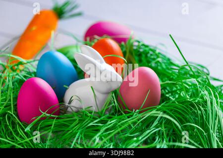 Osterhasen und Eier auf hölzernem Hintergrund. Wunderschöne Ostergrußkarte. Das Minimalkonzept von Ostern. Stockfoto
