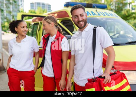 Multiethnische Sanitäter stehen auf dem FROMT eines Krankenwagens. Notarzt und Krankenschwester stehen vor dem Krankenwagen Stockfoto