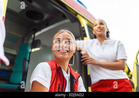 Zwei Krankenschwestern im Krankenwagen. Zwei Sanitäter am Krankenwagen, lächelnd. Stockfoto