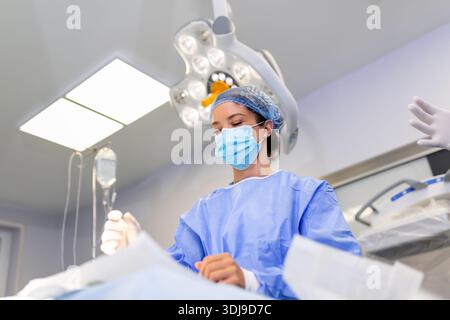 Gruppe von Chirurgen bei der Arbeit im Operationssaal in blau getönt. Ärzteteam Tätigkeit Stockfoto