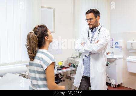 Kaukasischer männlicher Arzt in weißer medizinischer Uniform sprechen Ergebnisse oder Symptome mit weiblicher Patientin, Mann Hausarzt oder Arzt konsultieren Frau Klientin geben REC Stockfoto