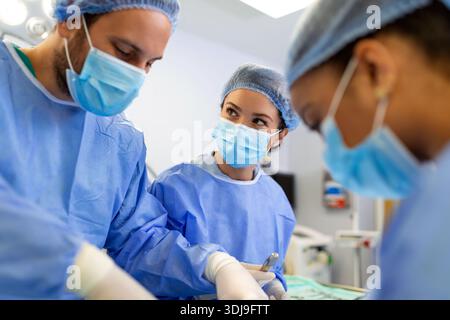 Chirurgen in einem hellen Operationssaal führen plastische Operationen durch, ein Team von Ärzten und Ärzten führt rekonstruktive Operationen durch. Stockfoto