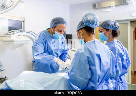 Gruppe von Ärzten, die dringend chirurgische Operationen durchführen und Patienten im Theater im Krankenhaus helfen. Medizinisches Team, das chirurgische Operationen in einem br Stockfoto