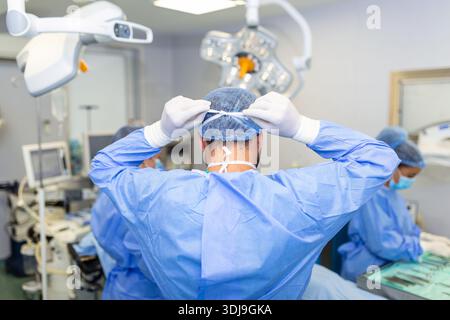 Rückansicht eines Chirurgen mit chirurgischer Maske im Operationssaal im Krankenhaus Stockfoto