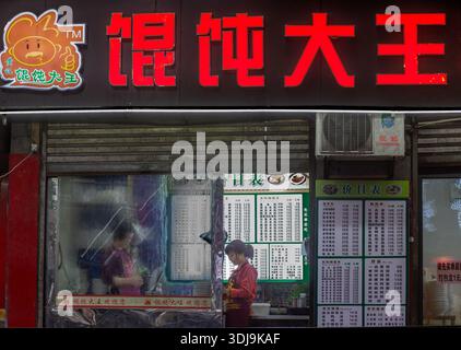 Blick von der Straße auf eine Kellnerin, die eine Bestellung in einem Restaurant entgegennimmt. Chongqing. China Stockfoto