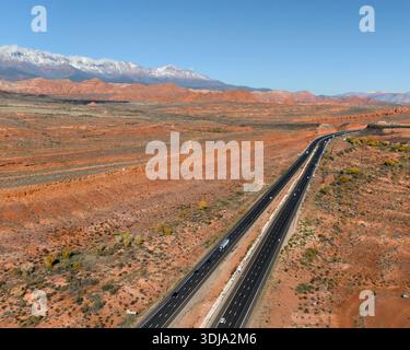 Gerader Wüstenautobahn mit schneebedeckten Gipfeln in der Nähe von Mesquite Nevada Stockfoto