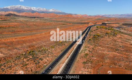 Highway durch die rote Wüste mit schneebedeckten Bergen in der Nähe von Mesquite Stockfoto