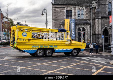 Viking Splash Tour Fahrzeug voller Touristen, die an Dublinia vorbeirasen und verspieltes Abenteuer mit der historischen Atmosphäre des mittelalterlichen Viertels D verbinden Stockfoto