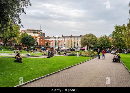 Im St Patrick’s Park neben der St Patrick’s Cathedral, einem der schönsten Grünflächen der Stadt, in Dublin, Irland, entspannen sich die Menschen auf dem Gras Stockfoto