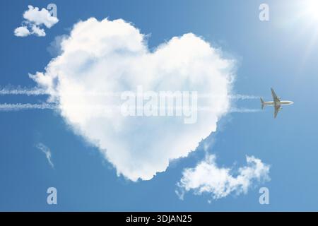 Niedliche flauschige Herzwolke mit fliegendem Flugzeug als durchdringender Pfeil im blauen Himmel Stockfoto