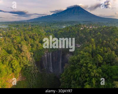 Luftaufnahme des Tumpak Sewu Wasserfalls mit dem Vulkan Mount Semeru in der Ferne, Ost-Java, Indonesien Stockfoto