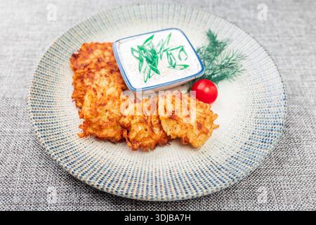 Draniki (traditionelle russische Kartoffelpfannkuchen) mit Hechtkaviar. Fünf Pfannkuchen liegen auf einem runden Teller, daneben ist eine Schüssel mit Hechtkaviar. Dekorat Stockfoto