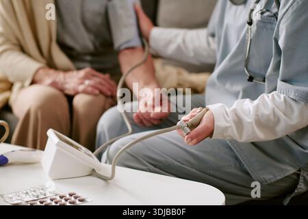 Kaukasierin mittleren Alters, deren Blutdruck von der Krankenschwester kontrolliert wird Stockfoto