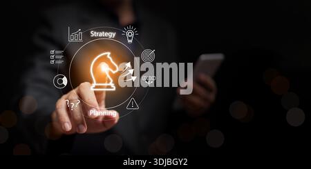 Geschäftsstrategie und Plankonzept. Geschäftsmann mit Smartphone zeigt auf Schachritter mit Strategie. Strategische Planung, Entscheidungsfindung, Wettbewerb Stockfoto