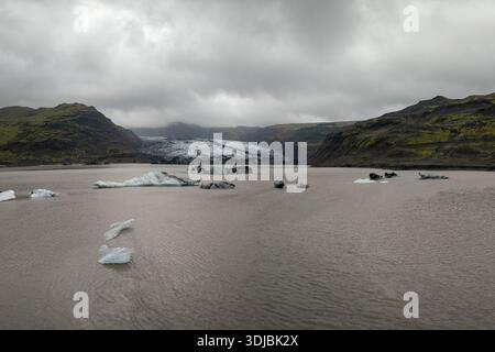 Ein Blick auf Eisberge in der Solheimajokull Gletscherlagune mit dem Myrdalsjokull Gletscher im Hintergrund Stockfoto