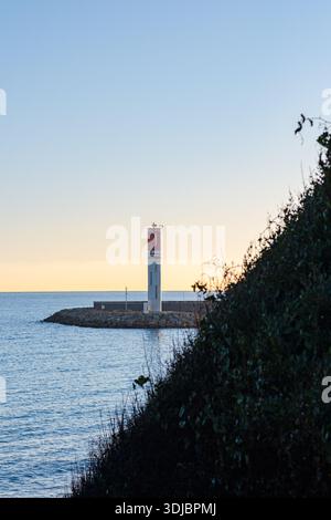 Ein malerischer Blick auf den berühmten Leuchtturm (Le Phare) in Antibes, Frankreich, der sich an einem Steinbruch an einem ruhigen Abend oder Morgen befindet. Highlights Stockfoto