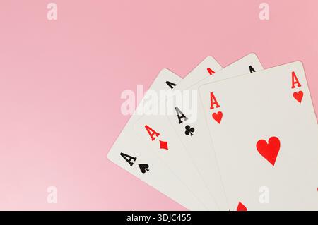 Draufsicht der Spielkarten auf rosafarbenem Hintergrund. Vier Asskarten, Brettspiel, Poker. Kopierraum, flach. Stockfoto