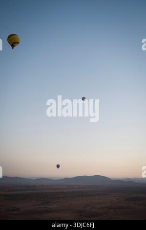 Drei Heißluftballons bei Sonnenaufgang über der Wüste in der Nähe von Marrakesch Stockfoto