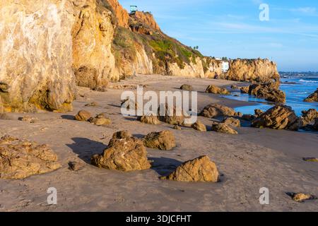 Herrliche goldene Klippen und einzigartige Felsformationen säumen die Sandfläche des El Matador State Beach, wo die Wellen des Pazifischen Ozeans sanft auf das Ufer treffen. Stockfoto