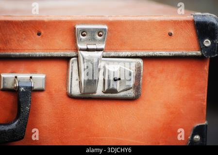 Vintage orange Koffer Nahaufnahme mit Metallverriegelung und Griff. Stockfoto