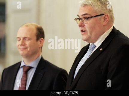 DUP-Chef Gavin Robinson, Abgeordneter (rechts), mit Gemeindeminister Gordon Lyons, MLA, im Gespräch mit den Medien in der Großen Halle der Parlamentsgebäude in Stormont. Bilddatum: Montag, 26. Januar 2026. Stockfoto