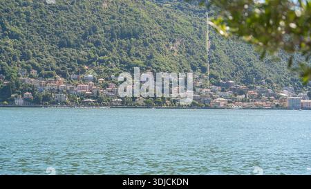 Weite Aussicht auf einen ruhigen Bergsee mit grünen Hügeln am Ufer. Natürliche Sommerlandschaft mit ruhiger Atmosphäre. Konzept von Natur, Reisen und Stockfoto