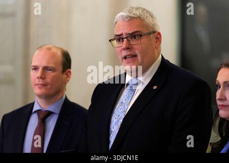 DUP-Chef Gavin Robinson Parlamentsabgeordneter und Gemeindeminister Gordon Lyons MLA (links) im Gespräch mit den Medien in der Großen Halle der Parlamentsgebäude in Stormont. Bilddatum: Montag, 26. Januar 2026. Stockfoto