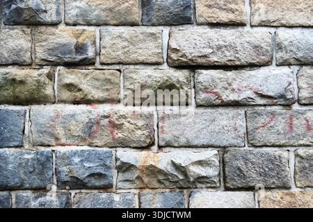 Nahaufnahme der traditionellen Steinblockmauer mit verwittertem Mauerwerk und natürlichen Farbvariationen Stockfoto