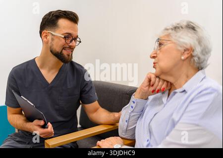 Männlicher Arzt, der die Schulter der besorgten älteren Frau berührt, um sie während der Routine-Krankenhausuntersuchung zu trösten Stockfoto