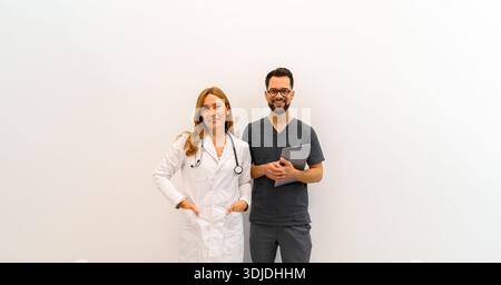 Porträt von Fachärzten mit Laptop und Stethoskop, die sicher vor weißem Hintergrund stehen Stockfoto