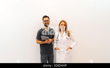 Porträt lächelnder Ärztinnen und Ärzte, die selbstbewusst stehen und sich vor weißem Hintergrund posieren Stockfoto