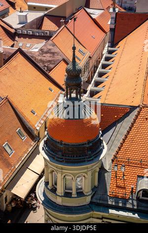 Eine vertikale Hochwinkelaufnahme mit einem wunderschönen historischen Eckturm in Maribor, Slowenien. Das Bild zeigt die grüne Fassade des Turms, den bogenförmigen Wind Stockfoto