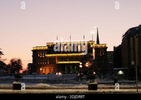 Regierungsgebäude mit festlichen Lichtern, die bei Sonnenuntergang leuchten, mit schneebedecktem Vorderboden im Zentrum von Belgrad. Belgrad, Serbien - 8. Januar Stockfoto