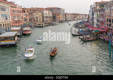 Ein Blick auf den Canal Grande in Venedig, Italien, mit verschiedenen Booten, darunter Gondeln, Wassertaxis und einem Vaporetto, die auf der von Hi gesäumten Wasserstraße navigieren Stockfoto