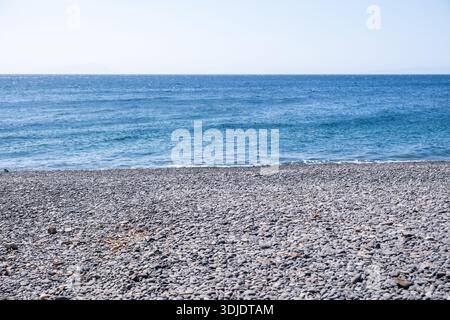 Mavra Volia Strand Schwarzes Kieselstrand auf der Insel Chios, Griechenland, mit Blick auf die ruhige Ägäis, plätschern sanfte Wellen an der Küste Stockfoto