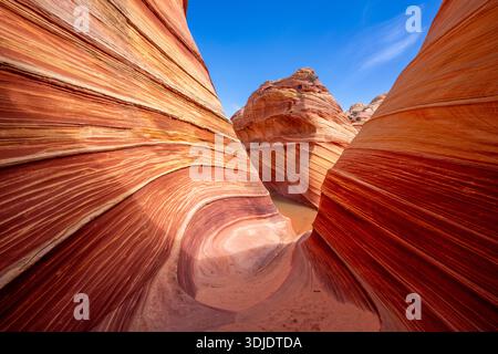 Die Wave, eine Sandsteinformation in den Coyote Buttes, Arizona, ist aufgrund ihres einzigartigen wirbelnden Musters ein beliebtes Ziel für Wanderer und Fotografen Stockfoto