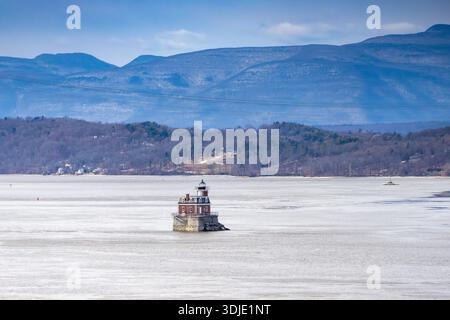 Aus der Vogelperspektive des historischen Hudson-Athens Lighthouse, der widerstandsfähig gegen den gedämpften, eisigen Fluss steht, mit den fernen Bergen unter einem weichen Himmel, HUD Stockfoto