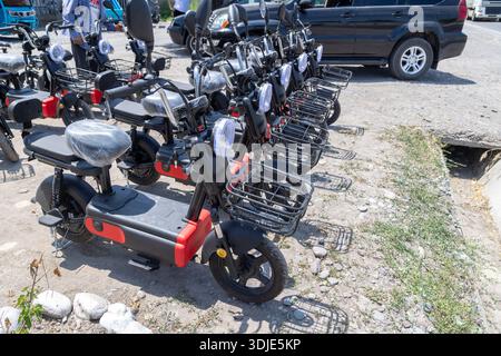 Auf den Straßen von Sokuluk, Kirgisistan, stehen am 23. Juni 2024 mehrere neue erschwingliche chinesische Elektroroller zum Verkauf Stockfoto