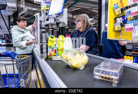 Samara, Russland - 12. April 2025: Ein Verkäufer betreut Kunden an der Kasse in einem Lenta Superstore Stockfoto