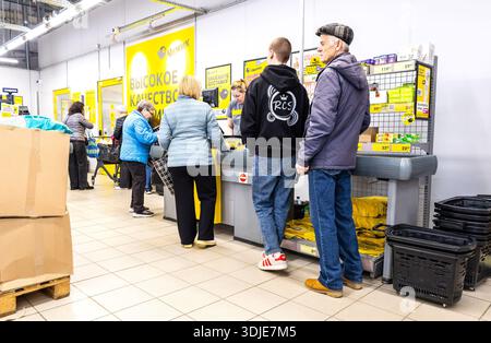Samara, Russland - 13. April 2025: Ein Verkäufer bedient Kunden an der Kasse in einem Lebensmittelgeschäft in Chischik Stockfoto